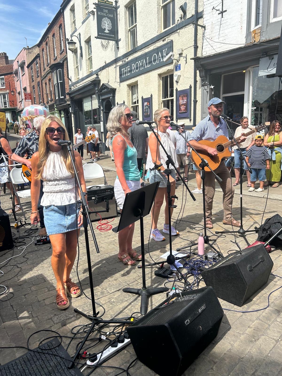 HG33 performing outdoors on a cobbled street in front of The Royal Oak